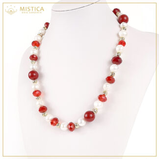 Collana di perle con sfere di cristallo rosso sfaccettato e zama, chiusura in argento 925% bagno oro. Lunghezza massima 52cm regolabile.